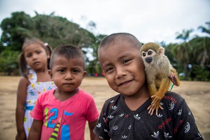 Young kids with monkey in Mataven indigenous village, Colombia. 