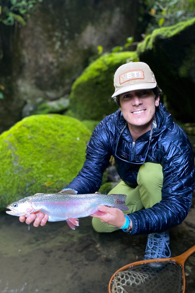 Fly angler and beautiful rainbow trout in cloud forest