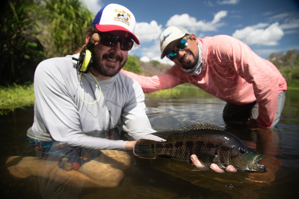 Angler and guide with large guapote cichlid